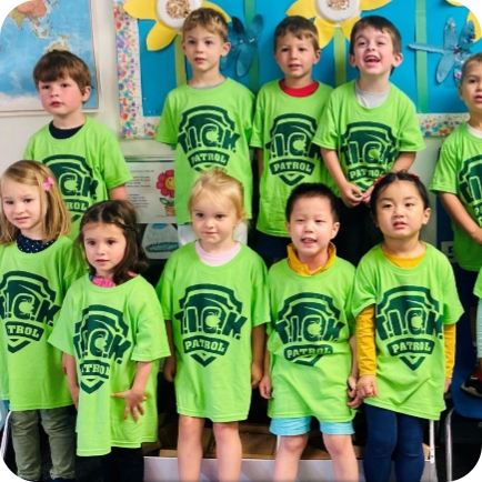 A diverse group of young children wearing bright green 