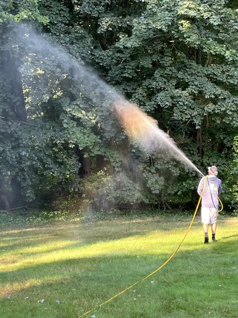 ohDEER technician spraying all-natural mosquito control up into the trees