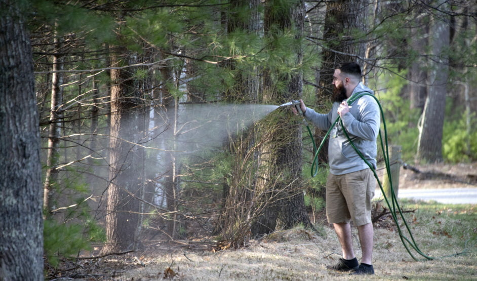 ohDEER technician spraying back into the woods line where ticks live 